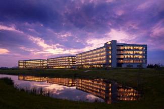 Large office building overlooking water at night