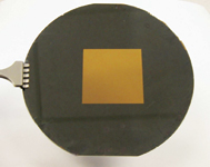 Figure 3. This image shows a 35 mm square poly-SiC membrane fabricated from a 2 μm– thick film on a 4 in. silicon wafer. The ability to control residual stress and thickness uniformity, combined with ultra-smooth polishing, results in a large-area membrane that is very flat, uniform, and transparent. This has been developed as a mask blank for next-generation lithography.