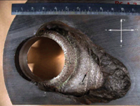 Figure 1. A football-sized eroded carbon steel section in the reactor vessel head exposed the nonpressure boundary cladding
