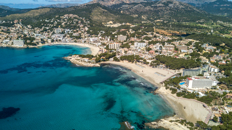 Aerial photograph of the three beaches of Paguera and their skykine, on a sunny summer day.