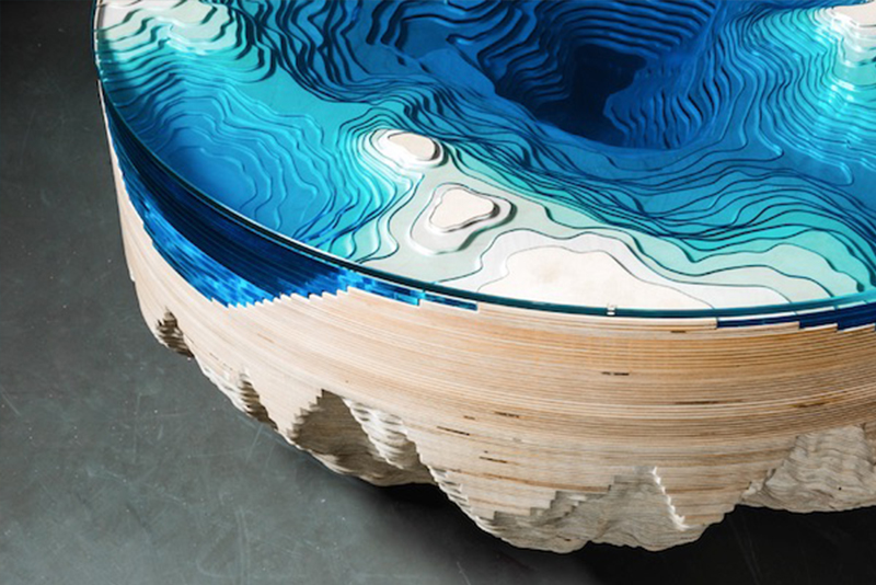 Abyss Horizon is a 3D coffee table that combines wood and glass to create an undulating blue and wood appearance