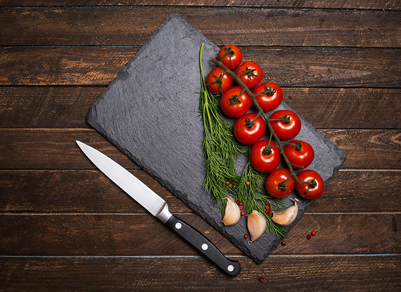 Cutting board with cherry tomato and garlic - pponomarevaiStockGetty Images PlusGetty Images