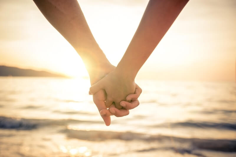 Couple Holding Hands on Beach - oneinchpunchiStockGetty Images PlusGetty Imagesjpg