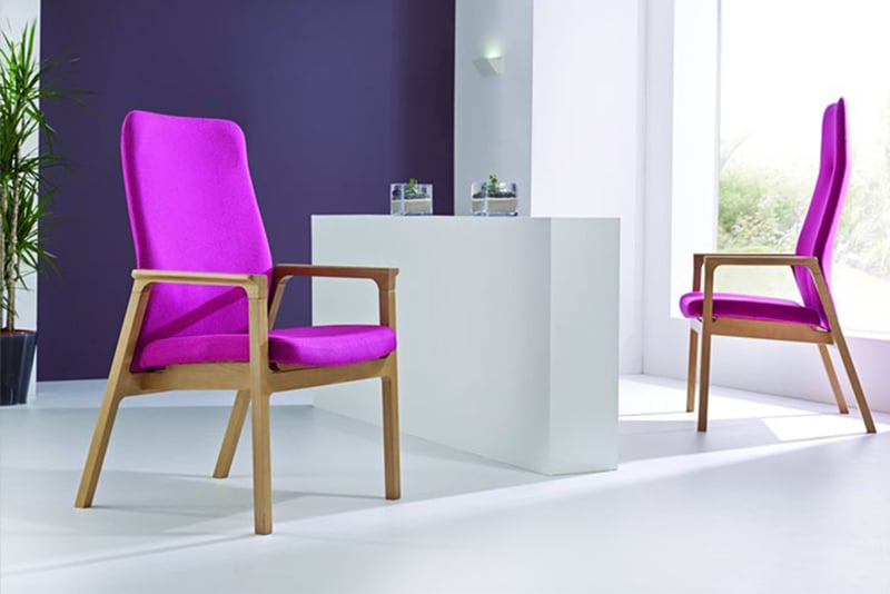 Columba seating by Webb Associates includes high back and mid back armchairs sculpted and thin with angled wooden legs and 