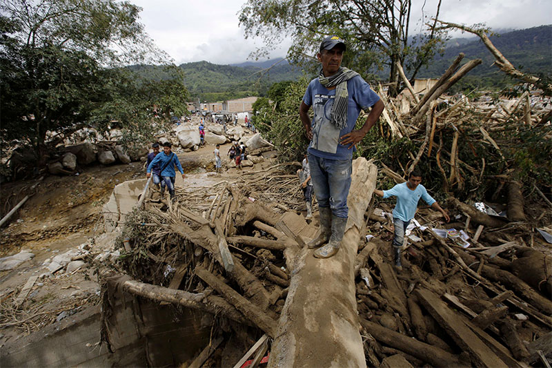 A man looks at a mud covered area in Mocoa Colombia