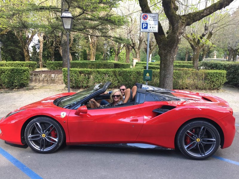 Julia Shore sitting in a red Ferrari