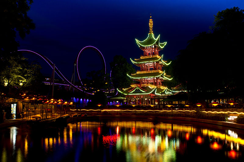 Pagoda and roller coaster in Tivoli Copenhagen lit up at night