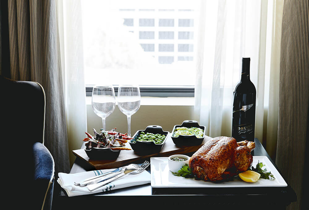 table with a cooked chicken and other dishes on it