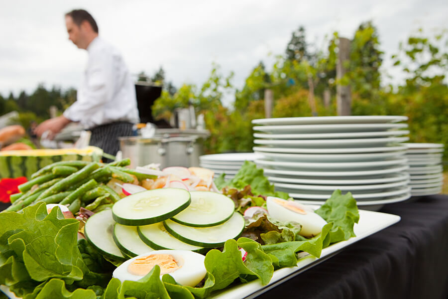 a table with food on it and a chef in the background