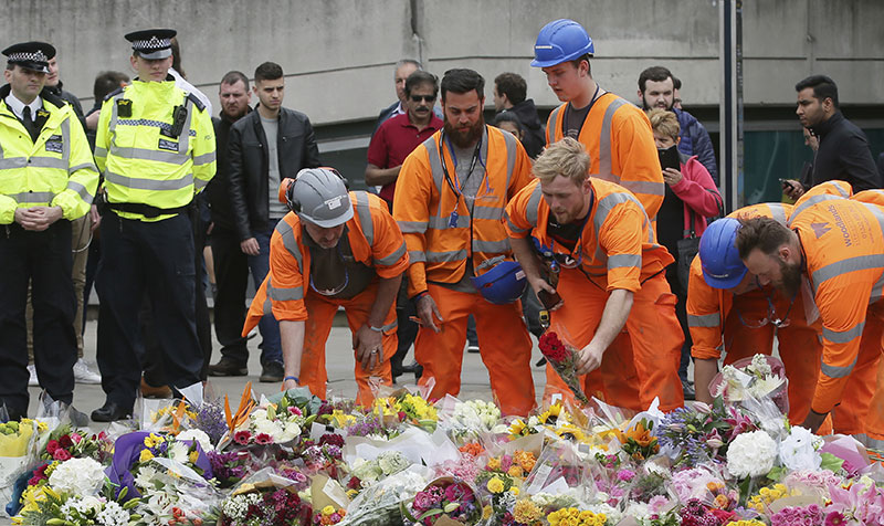 City workers lay flower tributes in the London Bridge area of London