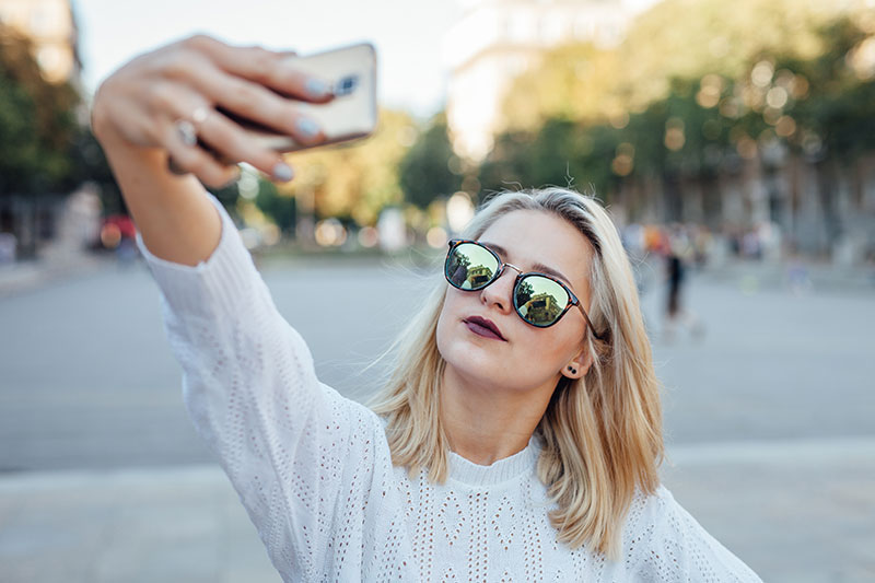 Young woman is taking a selfie by mobile phone