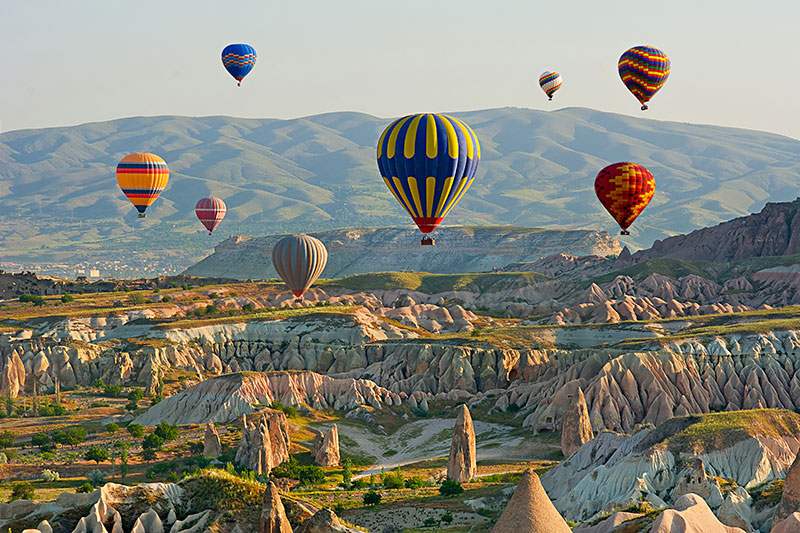 Colorful hot air balloons flying over the valley at Cappadocia Anatolia Turkey