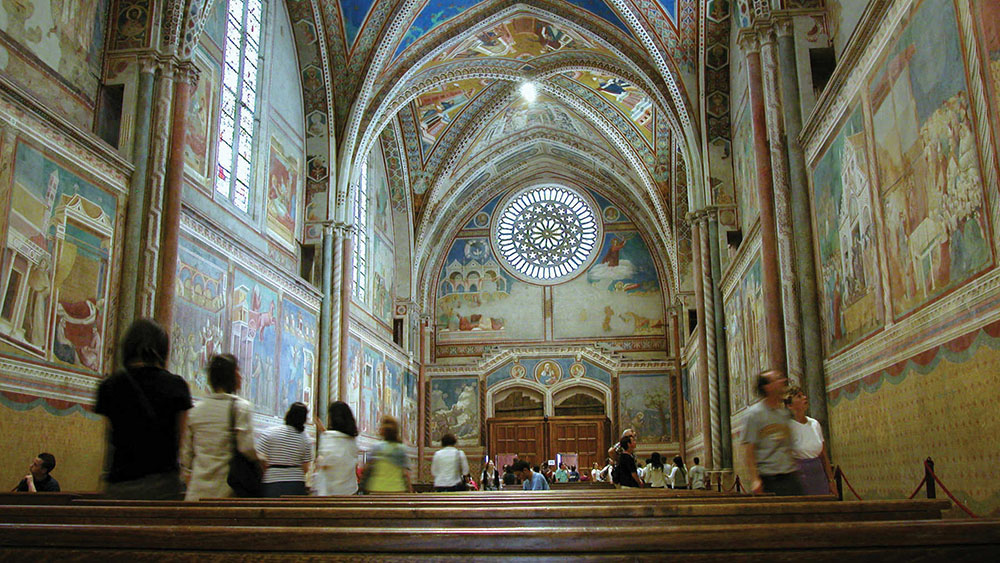 A view from a pew of the frescoed walls and ceilings of Assisis Basilica of St Francis