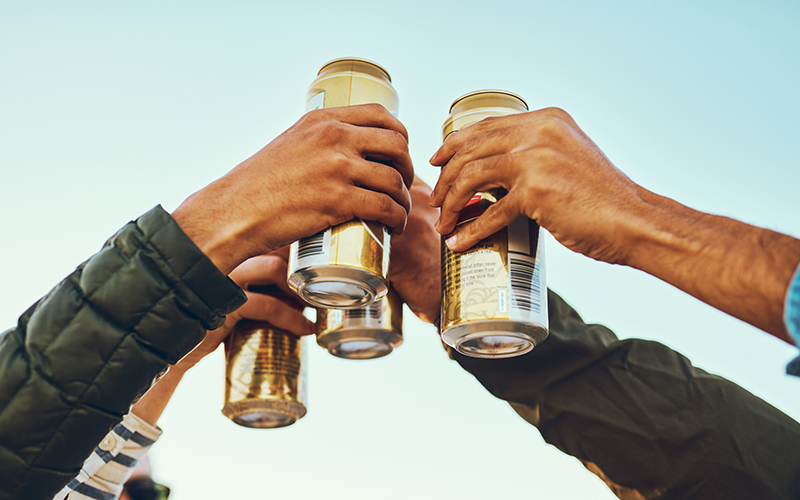 Group of friends toast with canned beverages