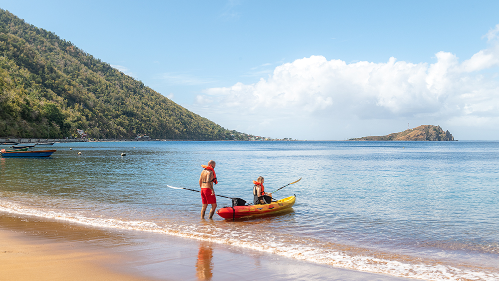 A man and a woman kayaking in Dominica