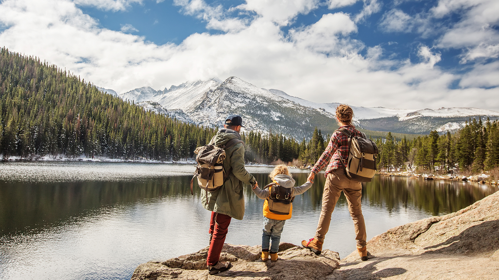 parents with young kid hiking in Rocky Mountains 