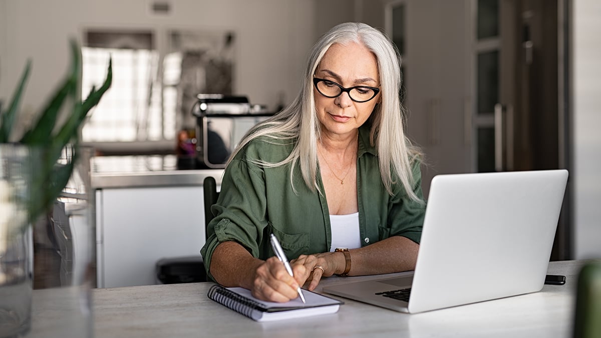 Woman on laptop taking notes