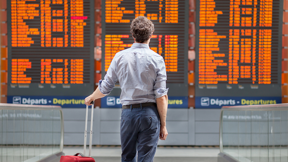 Man at airport looking at departure board