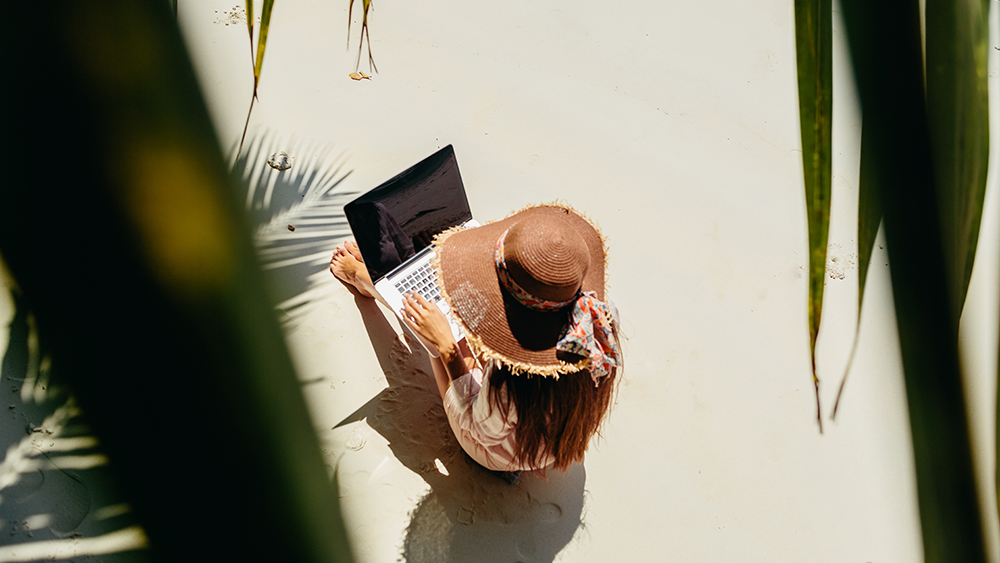 Woman on laptop on the beach