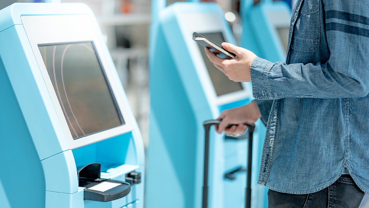 Man scanning passport at airport kiosk