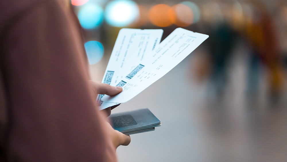 Person holding two plane tickets  boarding passes