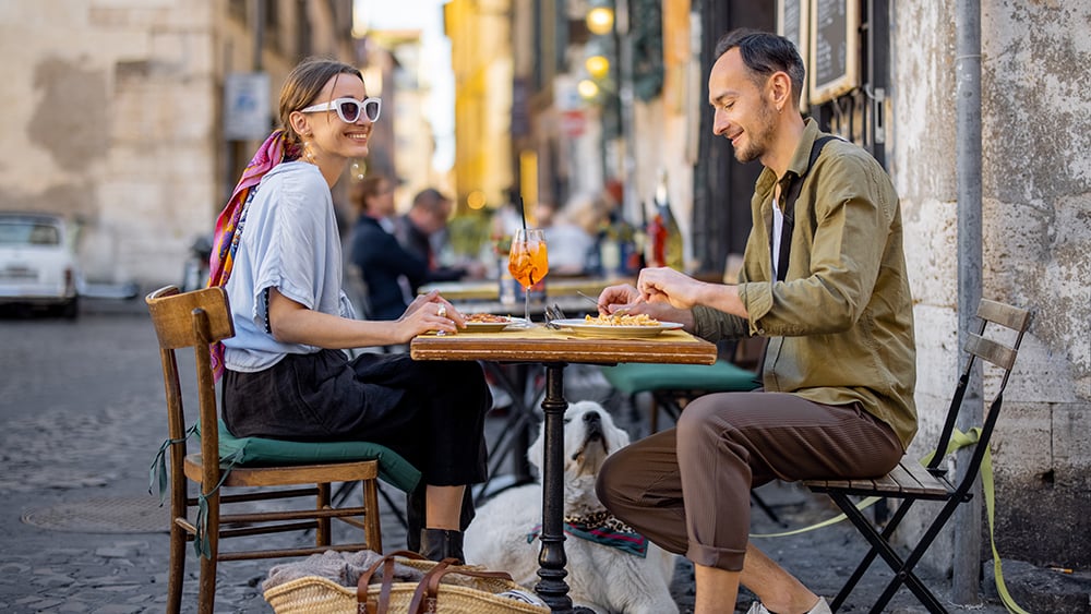 Man and woman eating at an outdoor cafe in Europe