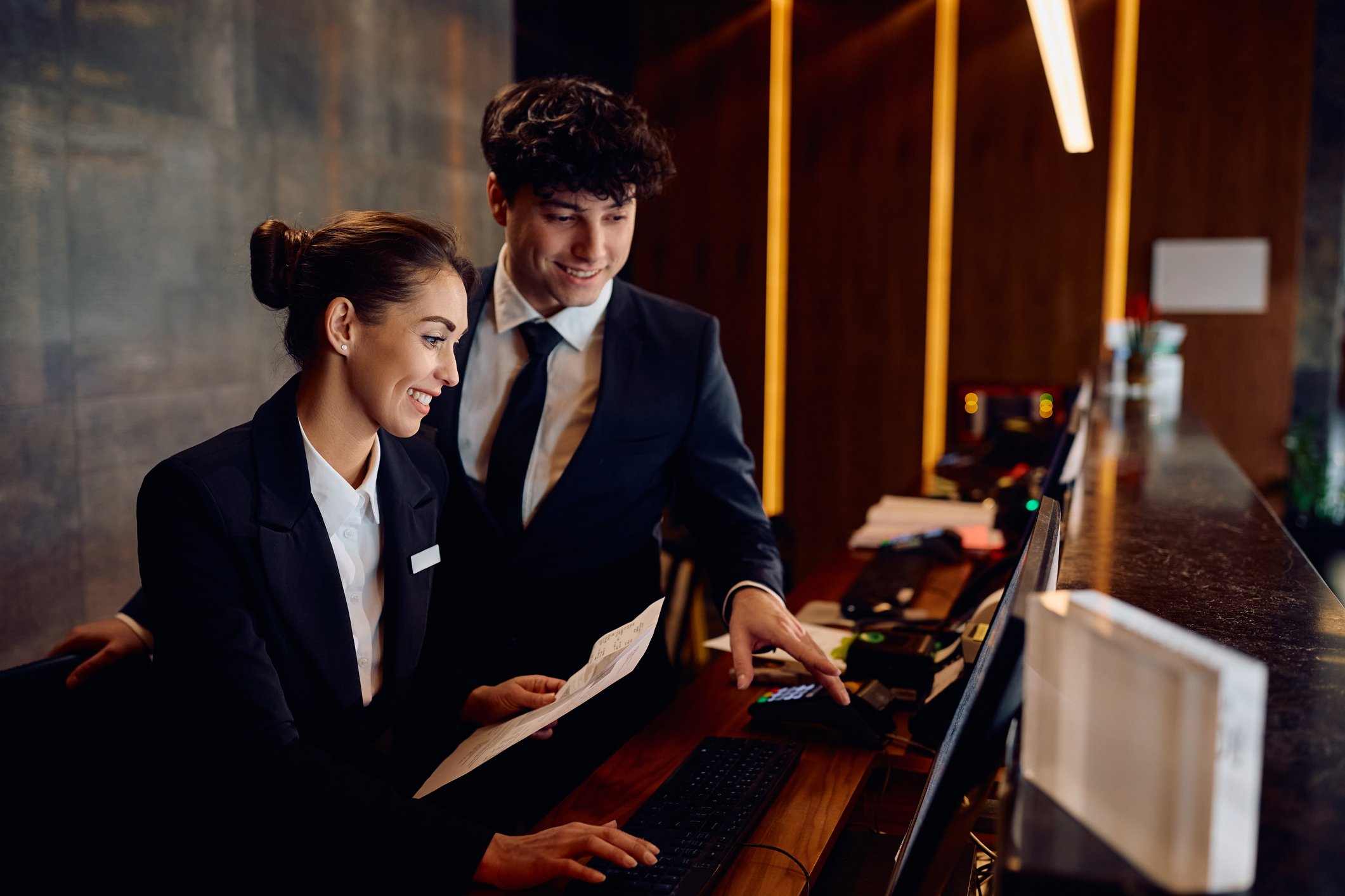 Two hotel receptionists working on front desk