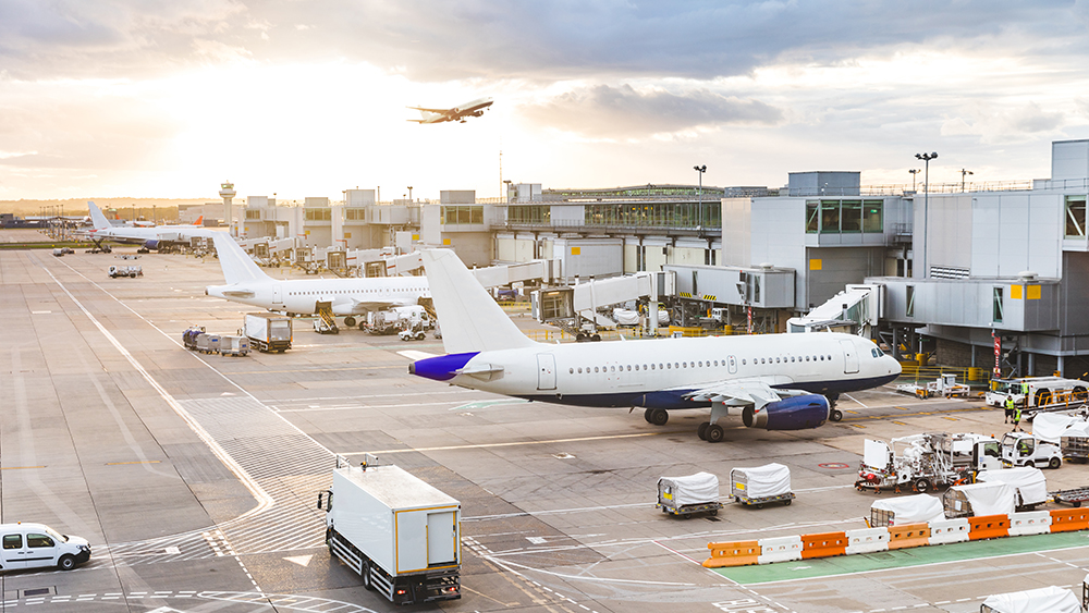 Airport with airplanes and service vehicles at sunset