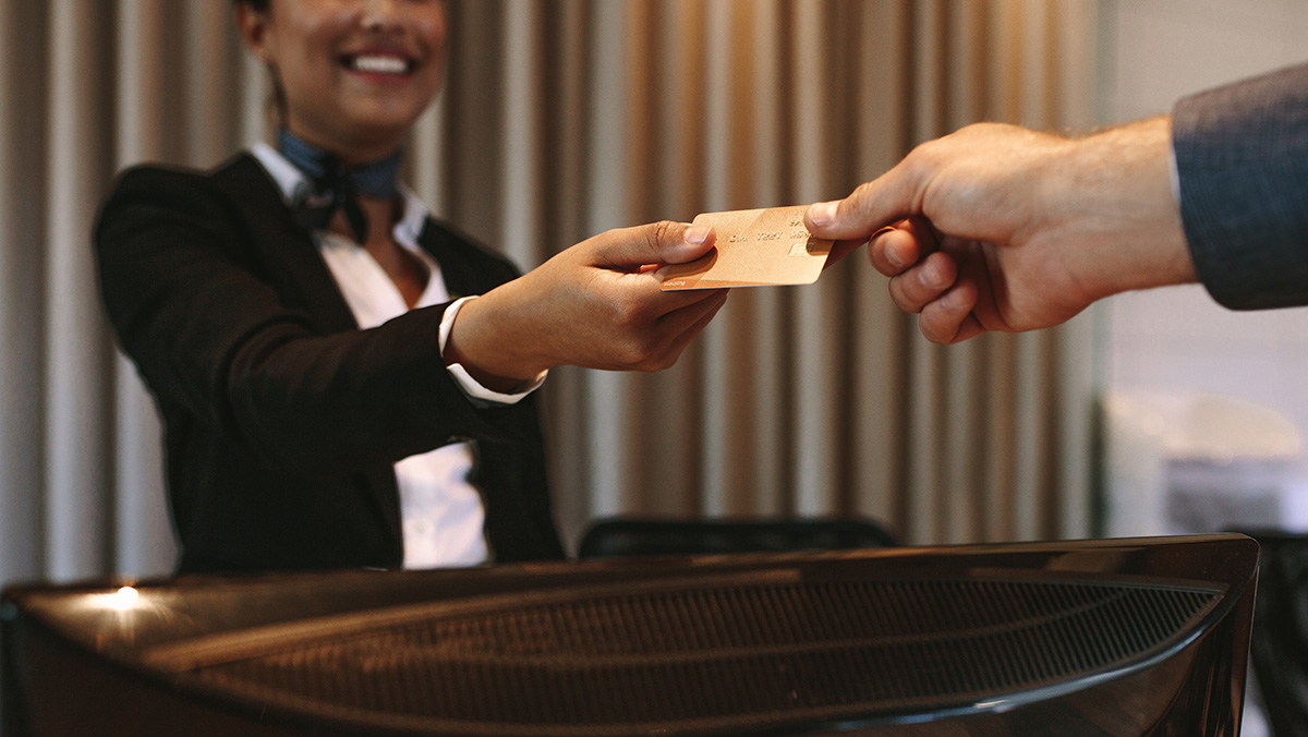 Man handing credit card to hotel employee