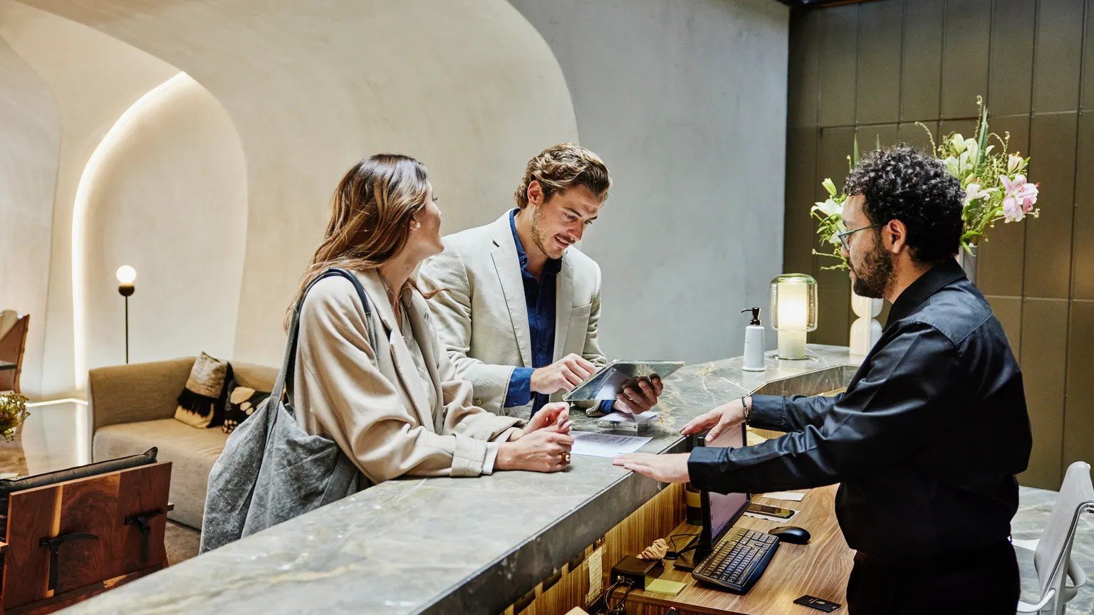 Hotel receptionist attending to couple