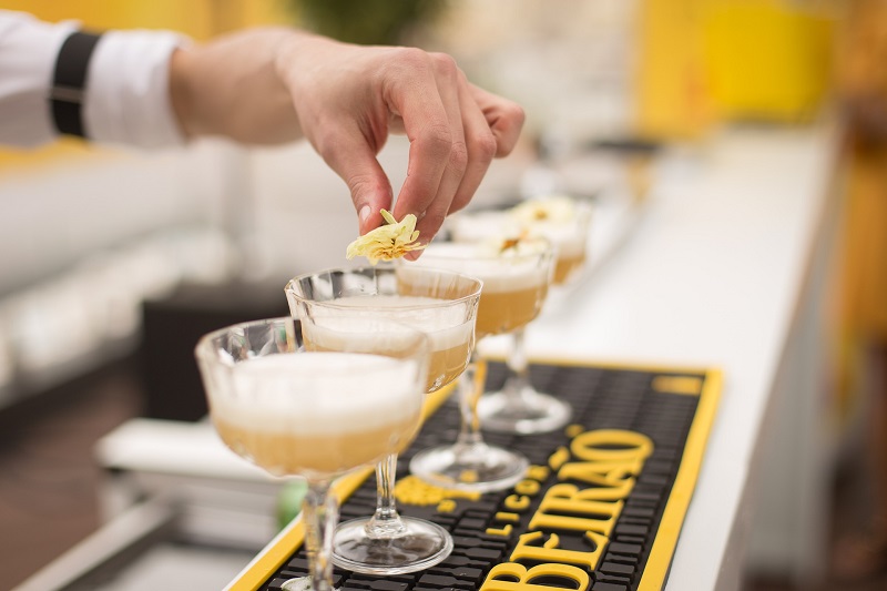 A bartender arranges cocktails on a bartop 