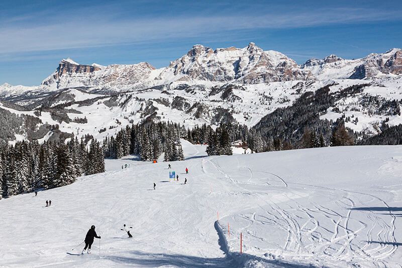 Skiers going down a mountain in Alta Badia Dolomites Italy