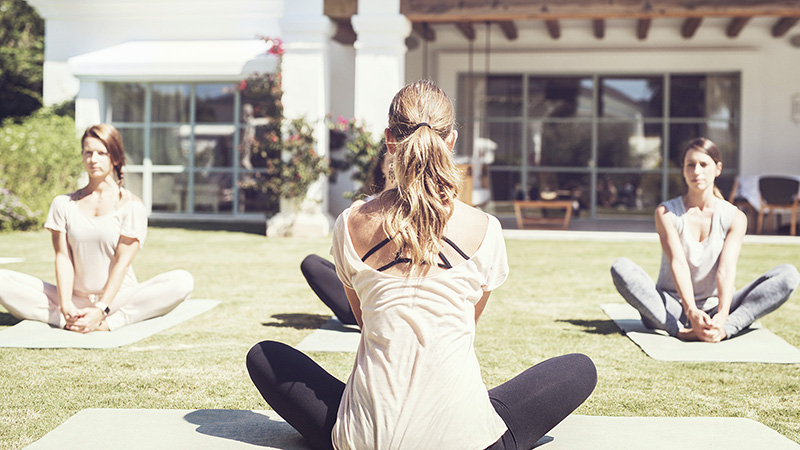Women practicing yoga on a lawn