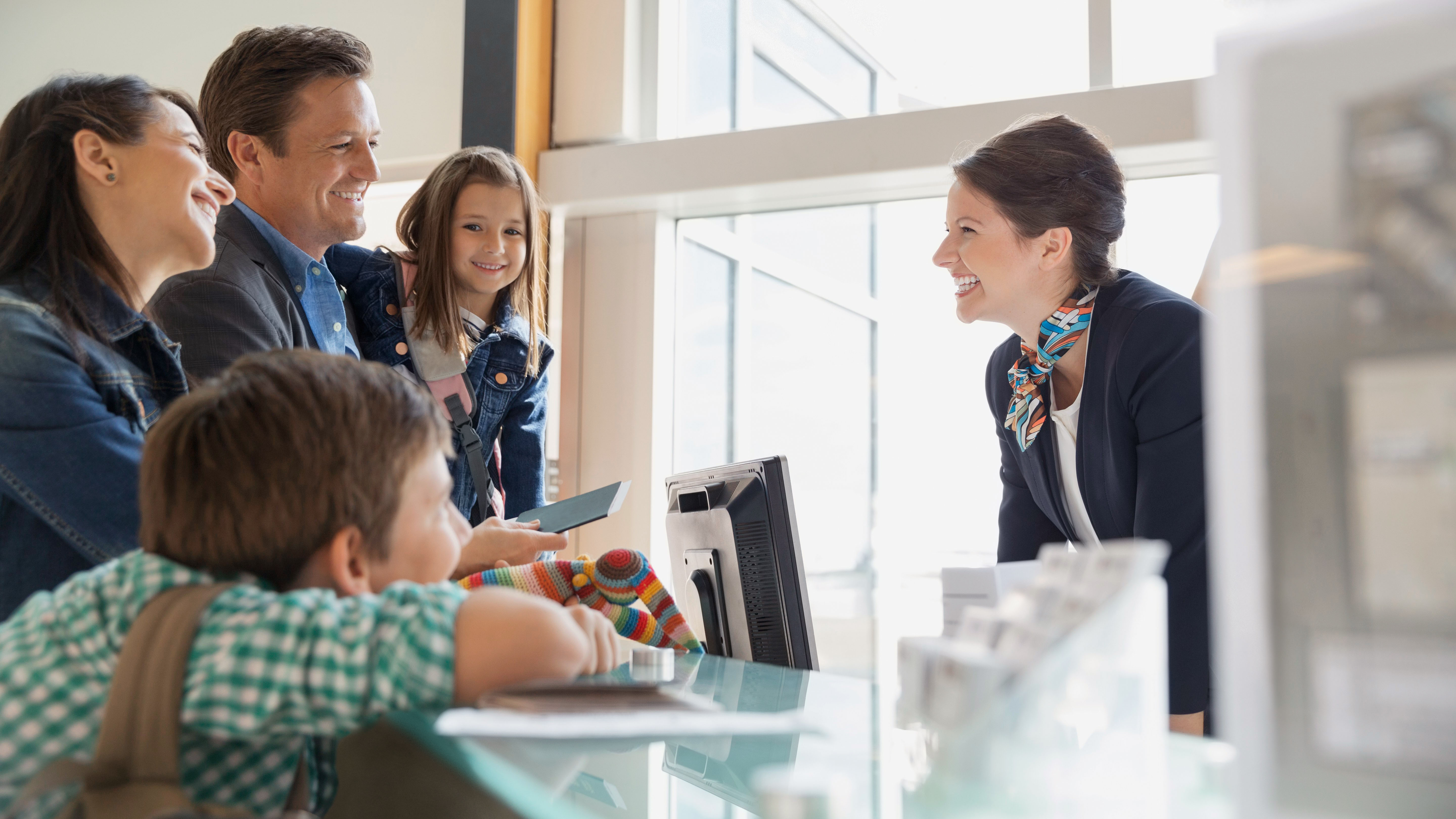 A family chats with a front desk clerk
