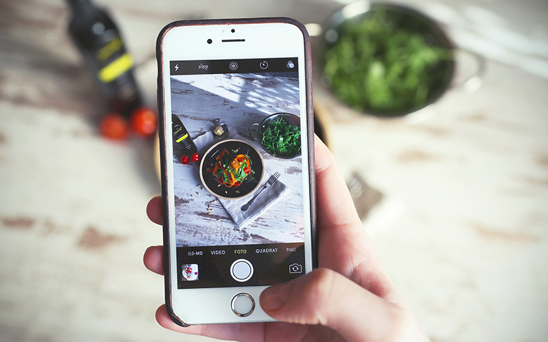 A person takes a photo of their food to post on social media