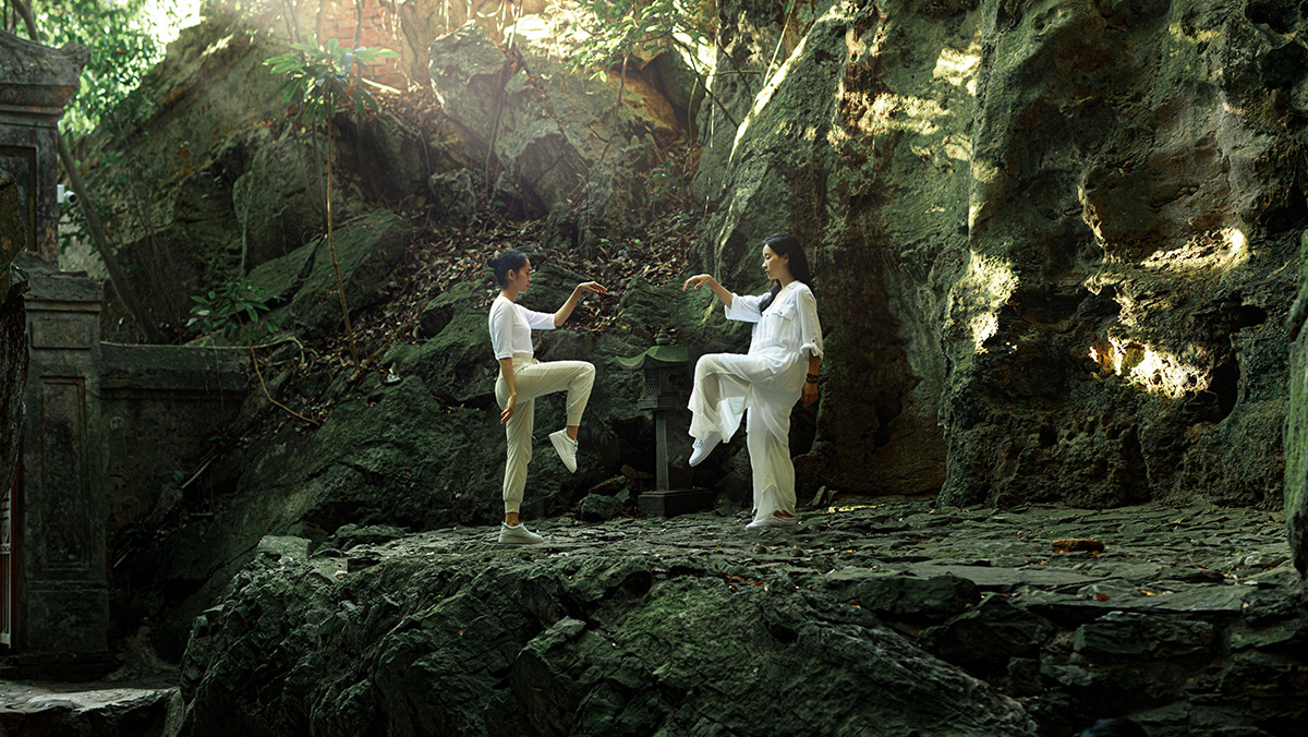 Two people practicing Tai Chi in nature