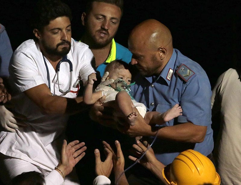 Rescuers pull out 7-month-old Pasquale from the rubble of a collapsed building in Casamicciola on the island of Ischia near