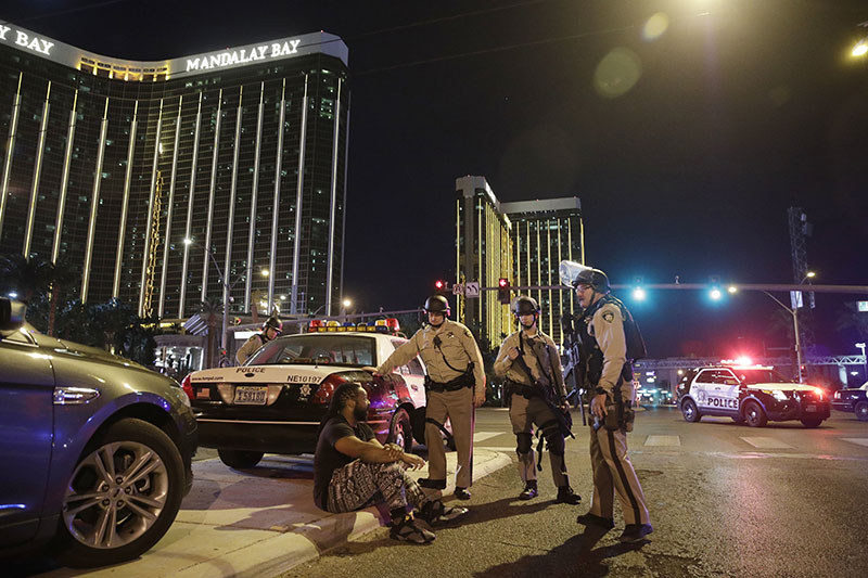 Police officers stand at the scene of a shooting near the Mandalay Bay resort and casino on the Las Vegas Strip