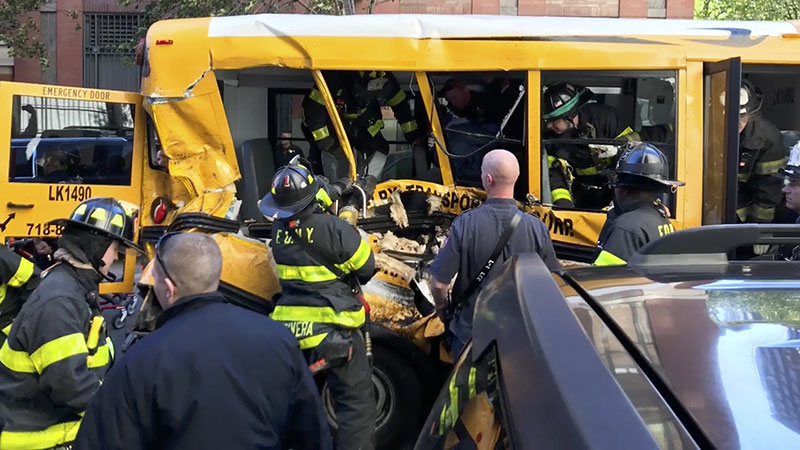 Emergency personnel work on a school bus after a driver rammed into it in New York 