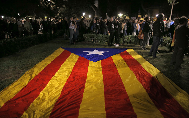 A pro-independence Catalan flag sits on the grass as demonstrators gather outside the Catalonian Parliament to protest again