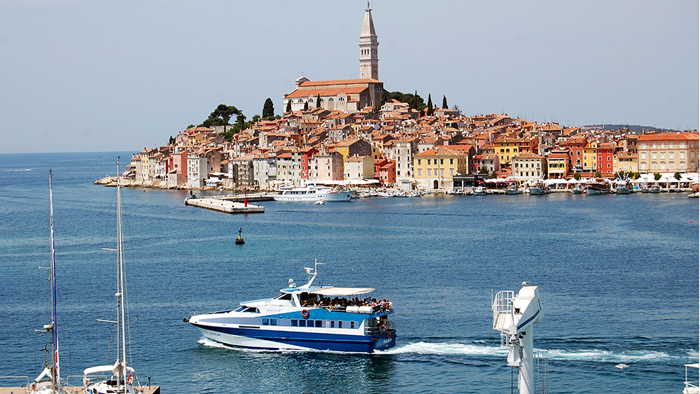 A seaside town in Croatia with red roofs and a boat in the foreground