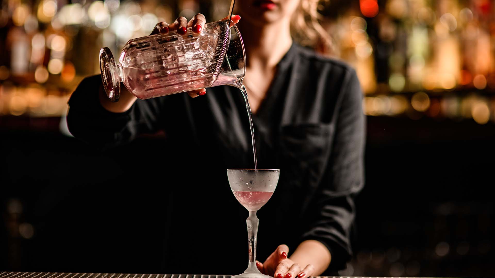 A bartender pours a beautiful cocktail 
