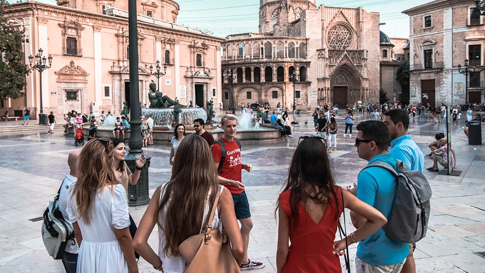 tour guide leading a group in European city