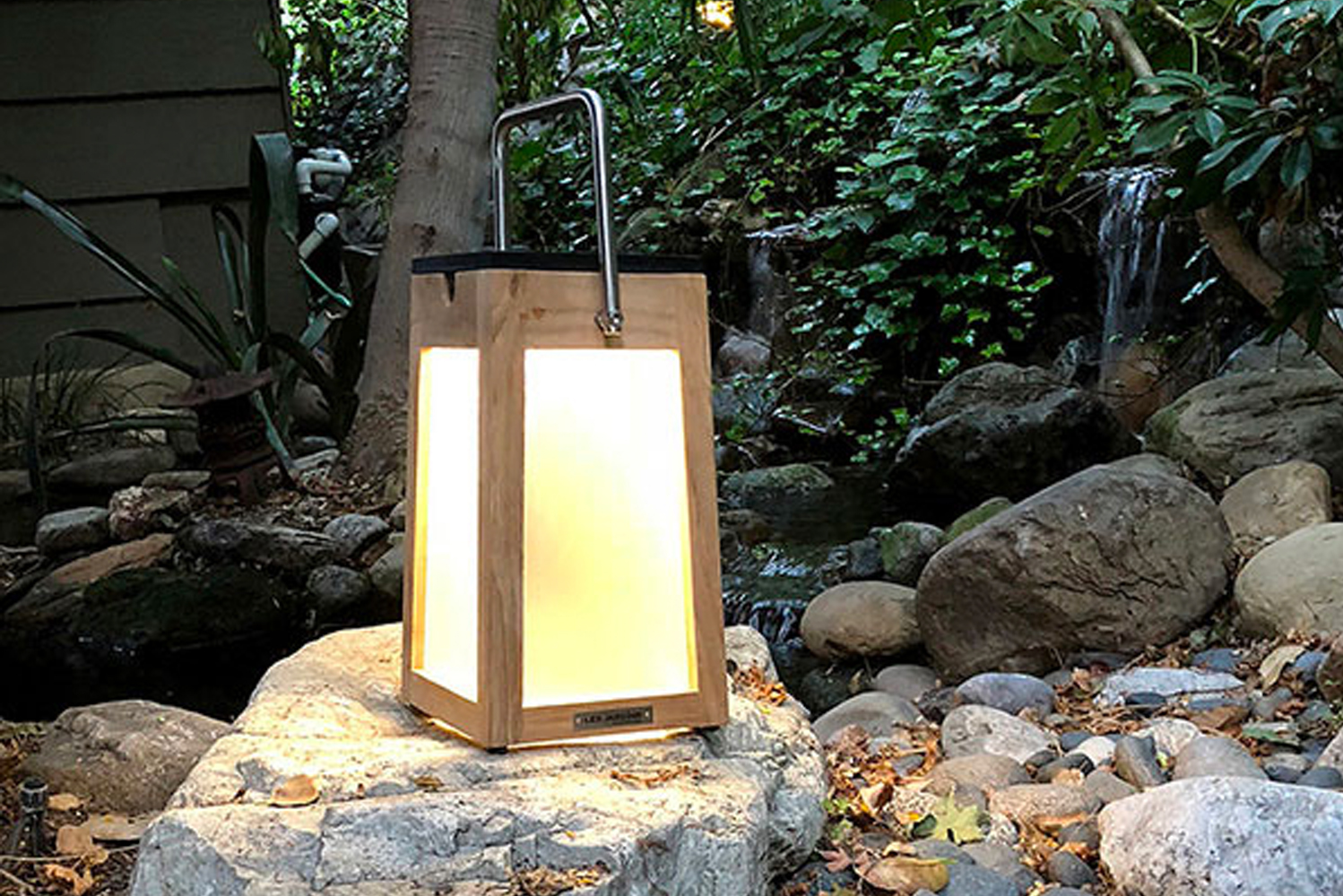 Made in a warm teak finish this outdoor lantern features clean lines a pivoting handle and a slightly tapered base for bala