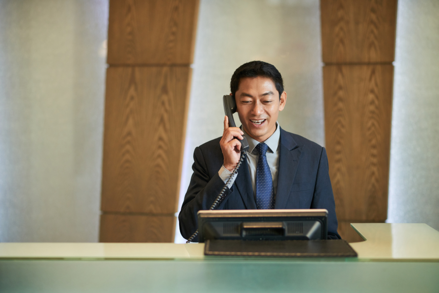 Front desk hotel employee on the phone