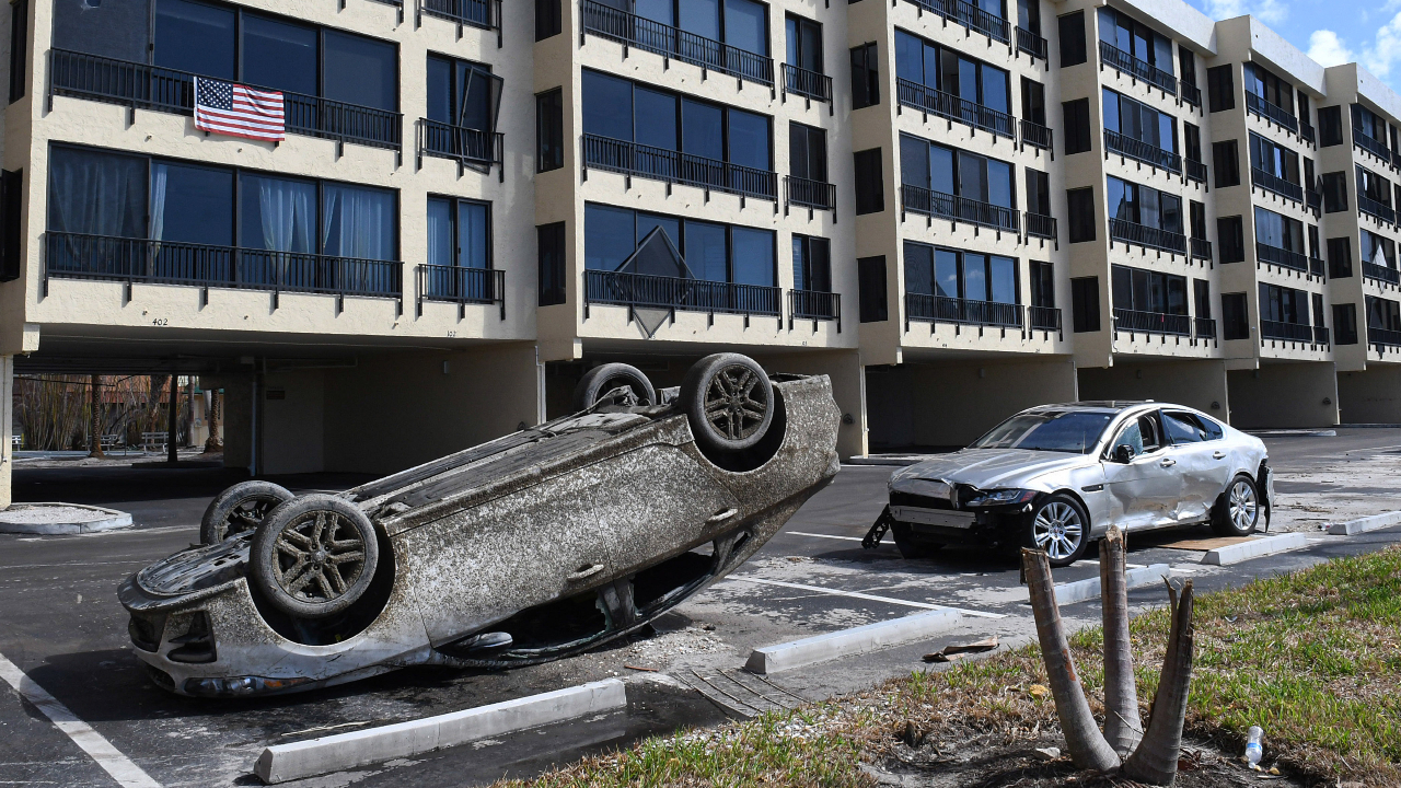 Destroyed cars are seen abandoned in a hotel parking lot