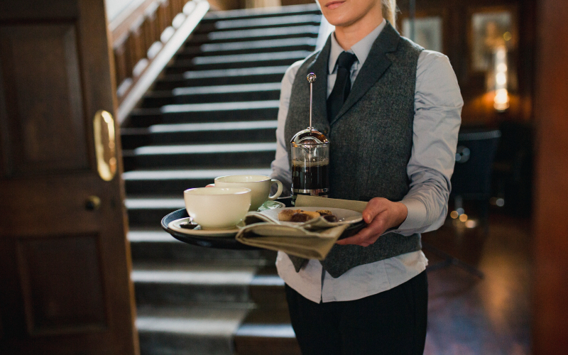 bartender holding a tray with coffee on