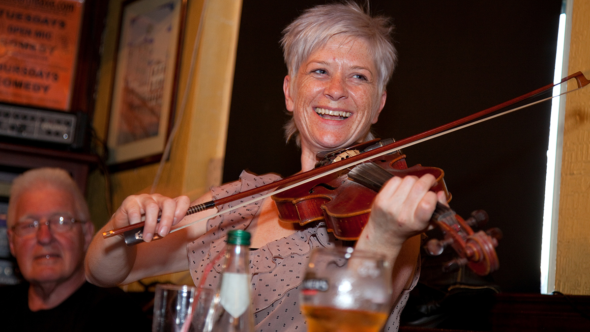 A woman playing a violin at an Irish pub