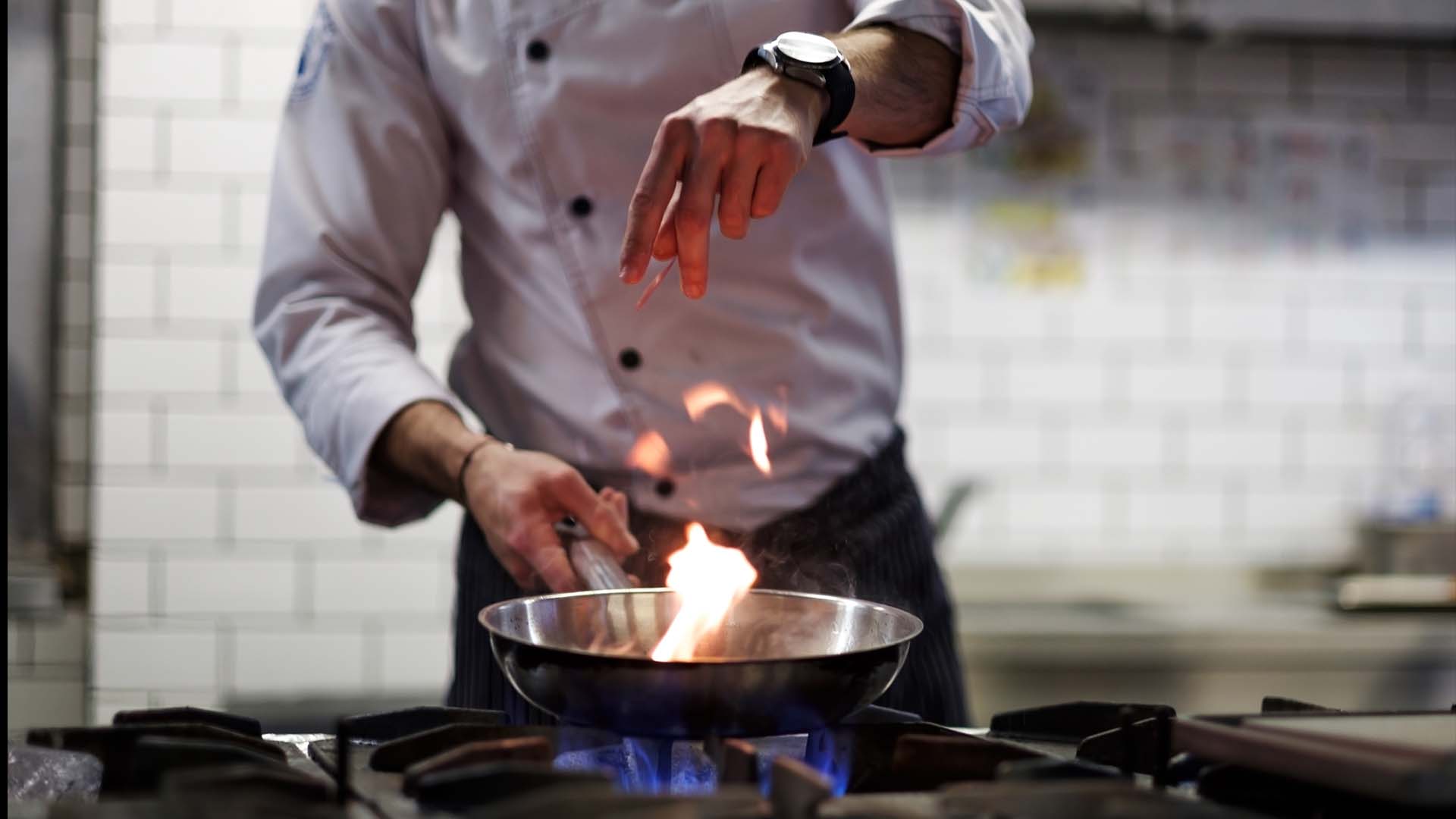 A chef flambes a dish