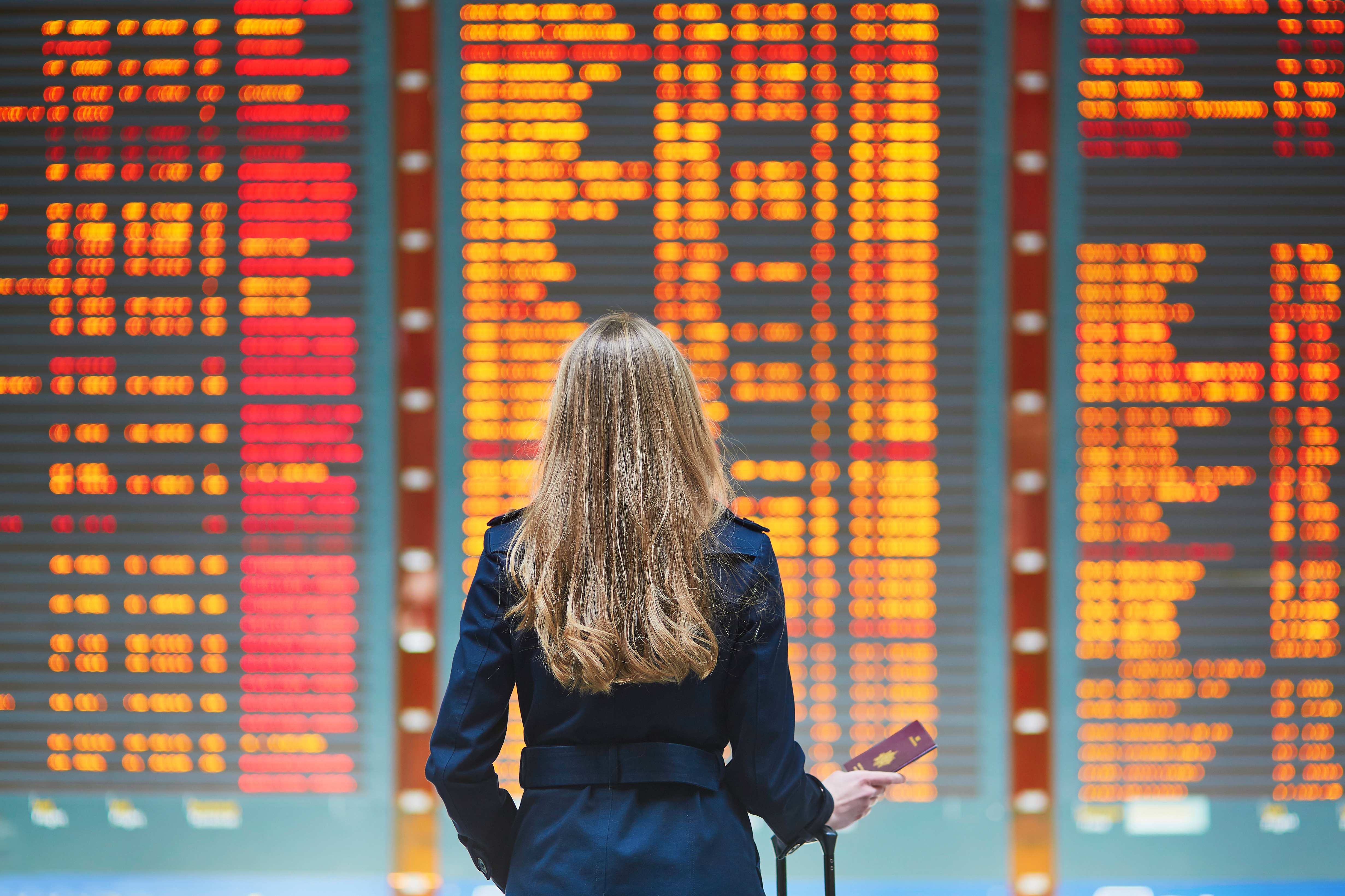 woman at airport looking at information board